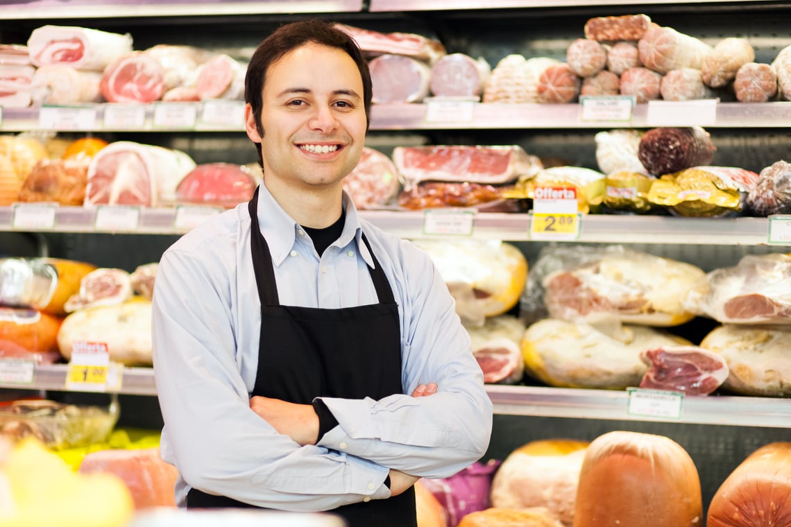 Smiling Shopkeeper in Meat Section