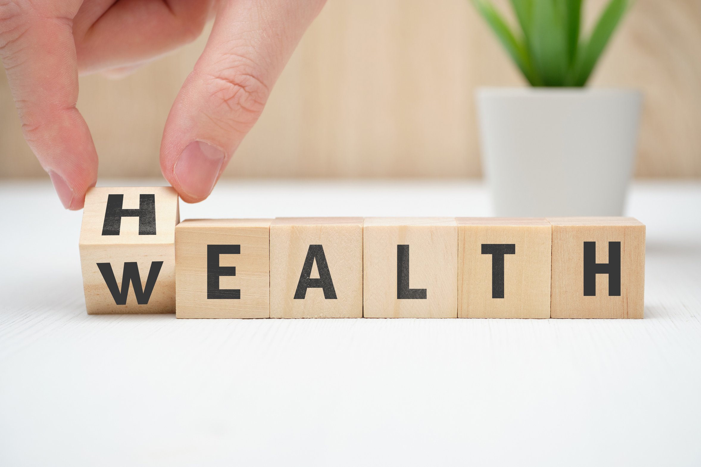 Concept health wealth on wooden block hold hand.